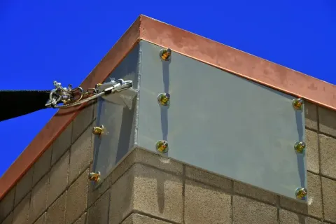 Close view of wall-connection plates and sail-tensioning hardware.