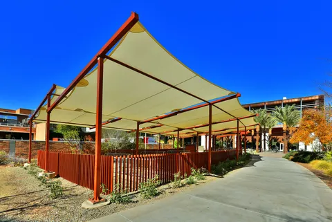 Broad shade panels above a fenced courtyard.