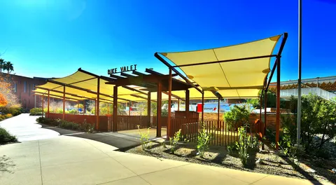 Shade panels surrounding a landscaped pedestrian area.