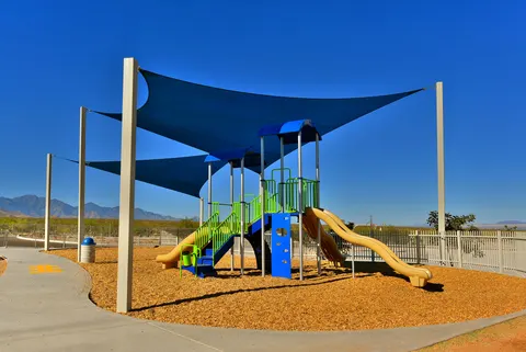 Shade sails above slides and climbing equipment.