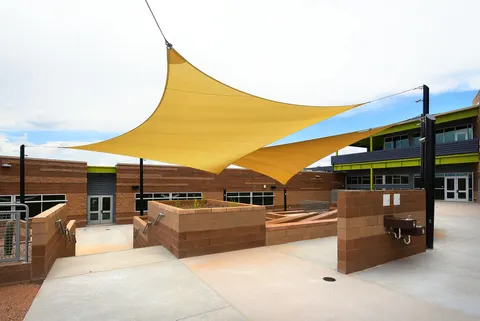 Shade sail spanning a courtyard between campus buildings.