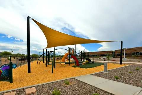 Yellow shade sail above an outdoor playground.