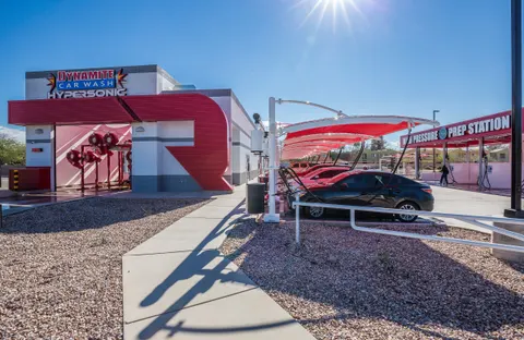 Wide view of red shade panels beside car-wash vehicle spaces.