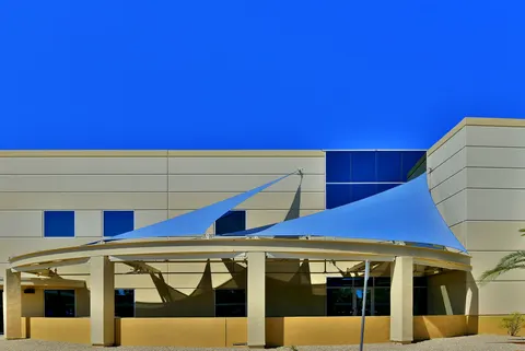 Blue shade panels beside a campus building entrance.