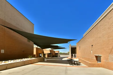Shade sails between buildings above a campus courtyard.