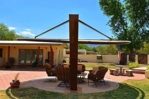 Light-colored patio umbrella above garden seating.