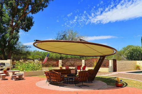Round patio umbrella above wicker seating.