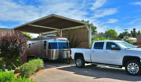 Wide view of a residential canopy above a travel trailer.