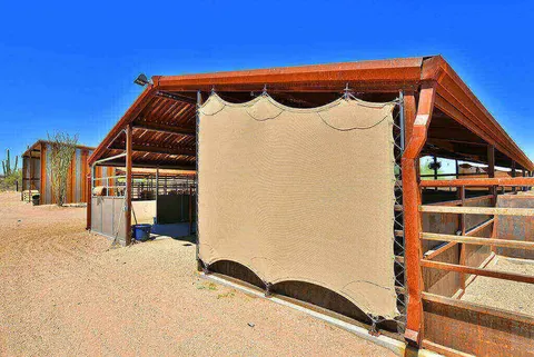 Side view of shade fabric attached to a horse-stall frame.