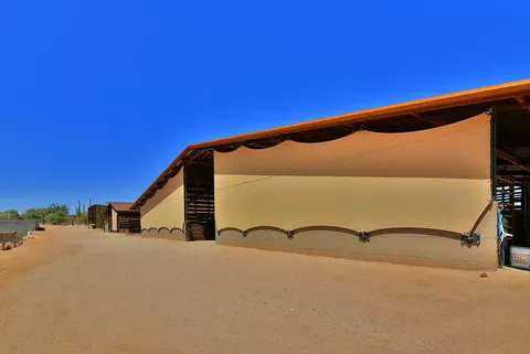 Wide view of vertical shade fabric beside a covered stall.