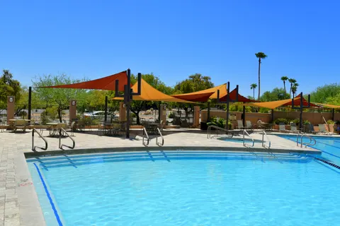 Wide view of shade sails surrounding a swimming pool.