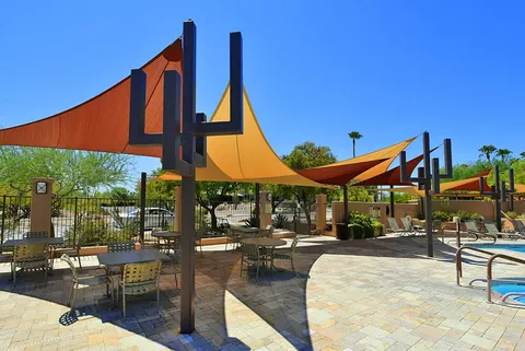 Shade sails and supports beside pool-deck gathering areas.