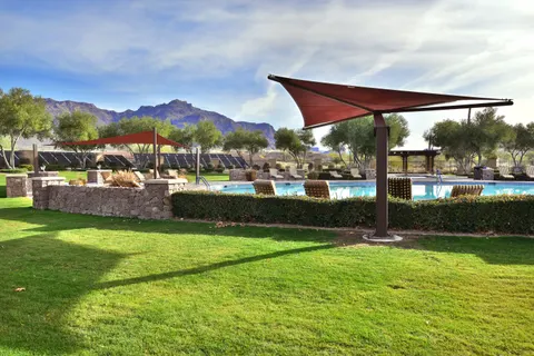 Side view of shade umbrellas beside a landscaped pool area.