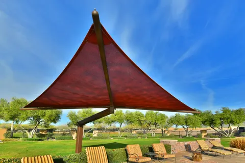 Upward view of a red peaked shade umbrella.