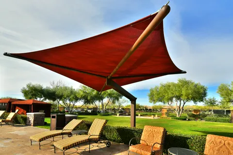 Red shade umbrella above outdoor lounge seating.