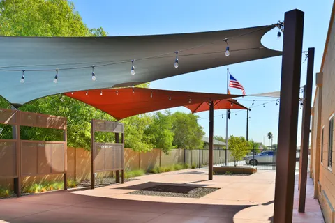 Light-colored shade sails above a paved courtyard.