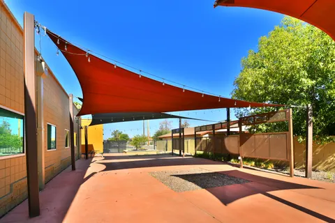 Red shade sails extending between courtyard posts.