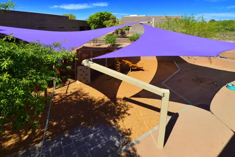 Overhead view of purple shade sails above playground areas.