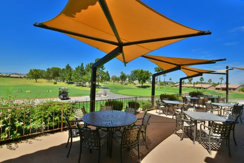 Yellow peaked umbrellas above outdoor dining tables.