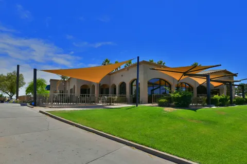 Wide view of yellow shade umbrellas along a building terrace.